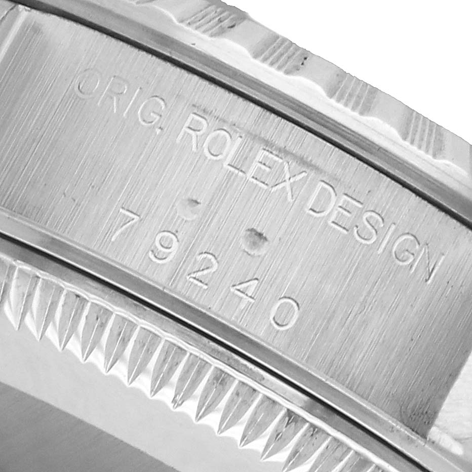 The image shows a close-up of the Rolex Date 79240 Women's Stainless Steel White Dial model's engraved watch case, highlighting the design and reference number.
