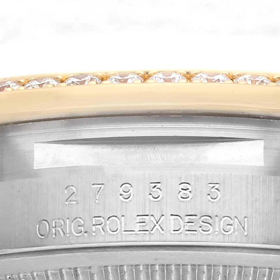 This close-up image shows the side of a Rolex Datejust 279383RBR Women's Steel and Gold (two tone) White Dial 279383RBR Women's Steel and Gold (two tone) White Dial, focusing on its engraved serial number and bezel with diamonds.