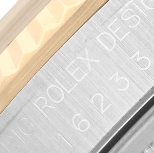 The image shows an angled view of the Rolex Datejust 16233 Men's Steel and Gold (two tone) Silver Dial 16233 Men's Steel and Gold (two tone) Silver Dial's bezel and edge of the case, highlighting engravings.