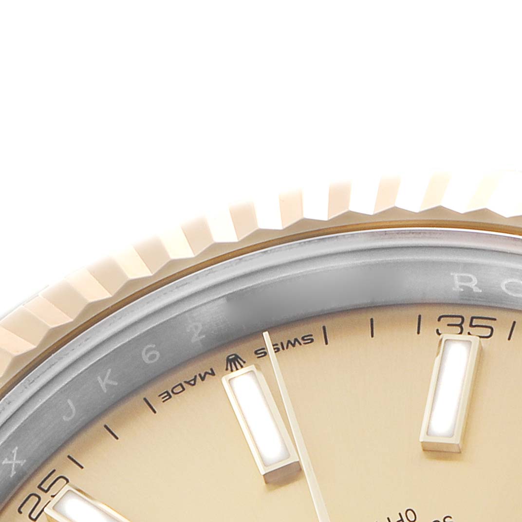 The close-up angle shows the edge of the dial, markers, and the fluted bezel of a Rolex Datejust 41 126333 Men's Steel and Gold (two tone) Champagne Dial.