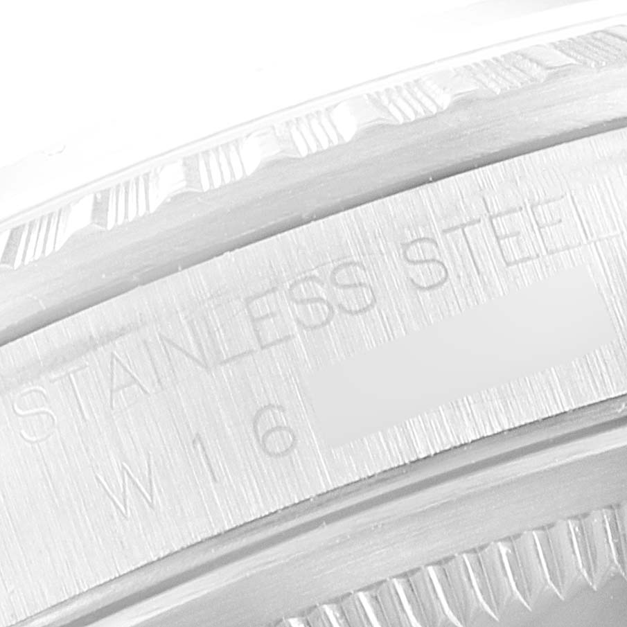 This close-up image shows part of the bezel and engraved text on the stainless steel case of a Rolex Datejust 16220 Men's Stainless Steel Silver Dial 16220 Men's Stainless Steel Silver Dial watch.
