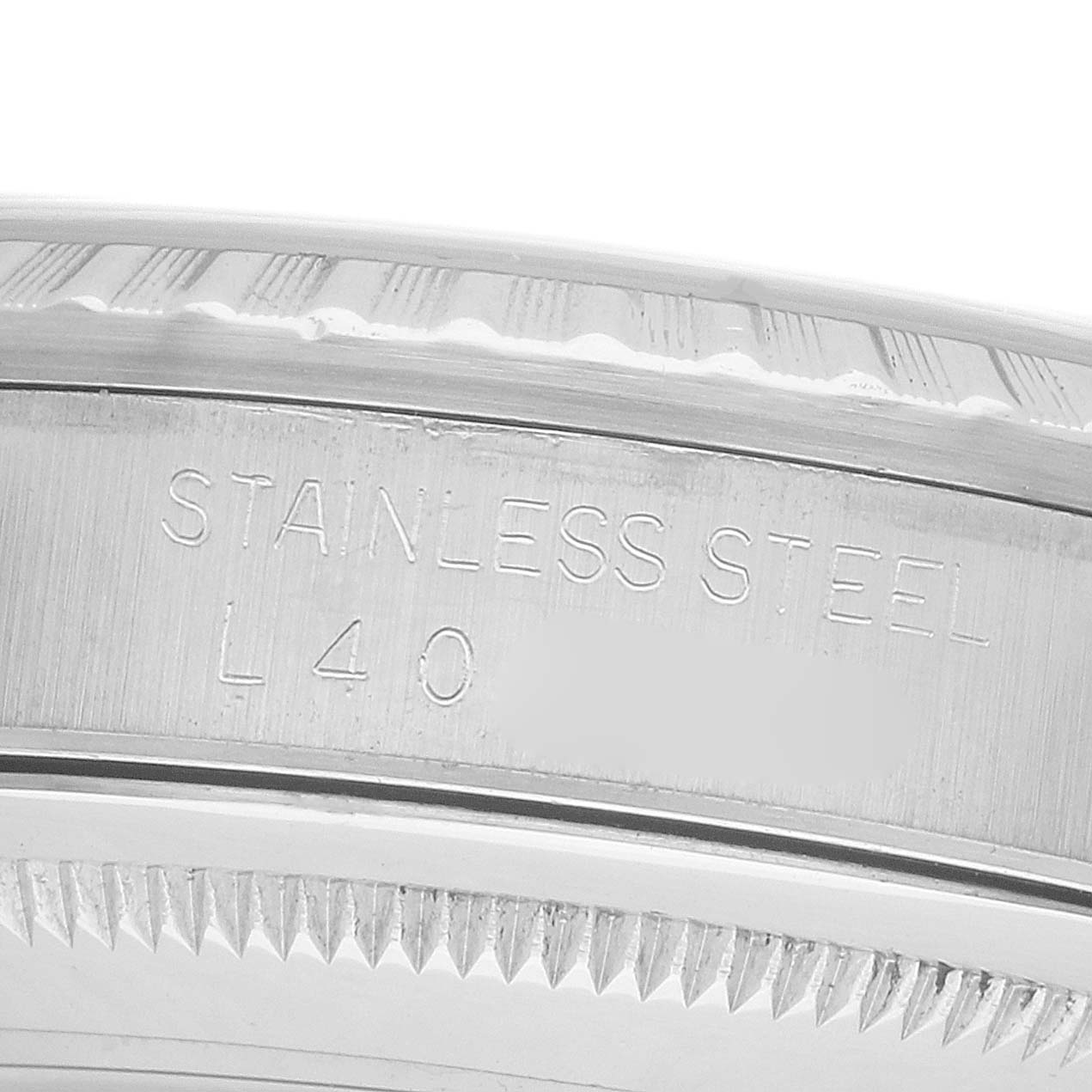 The image shows a close-up side view of the stainless steel rim and engraved lettering on a Rolex Datejust 16220 Men's Stainless Steel Beige Dial watch.