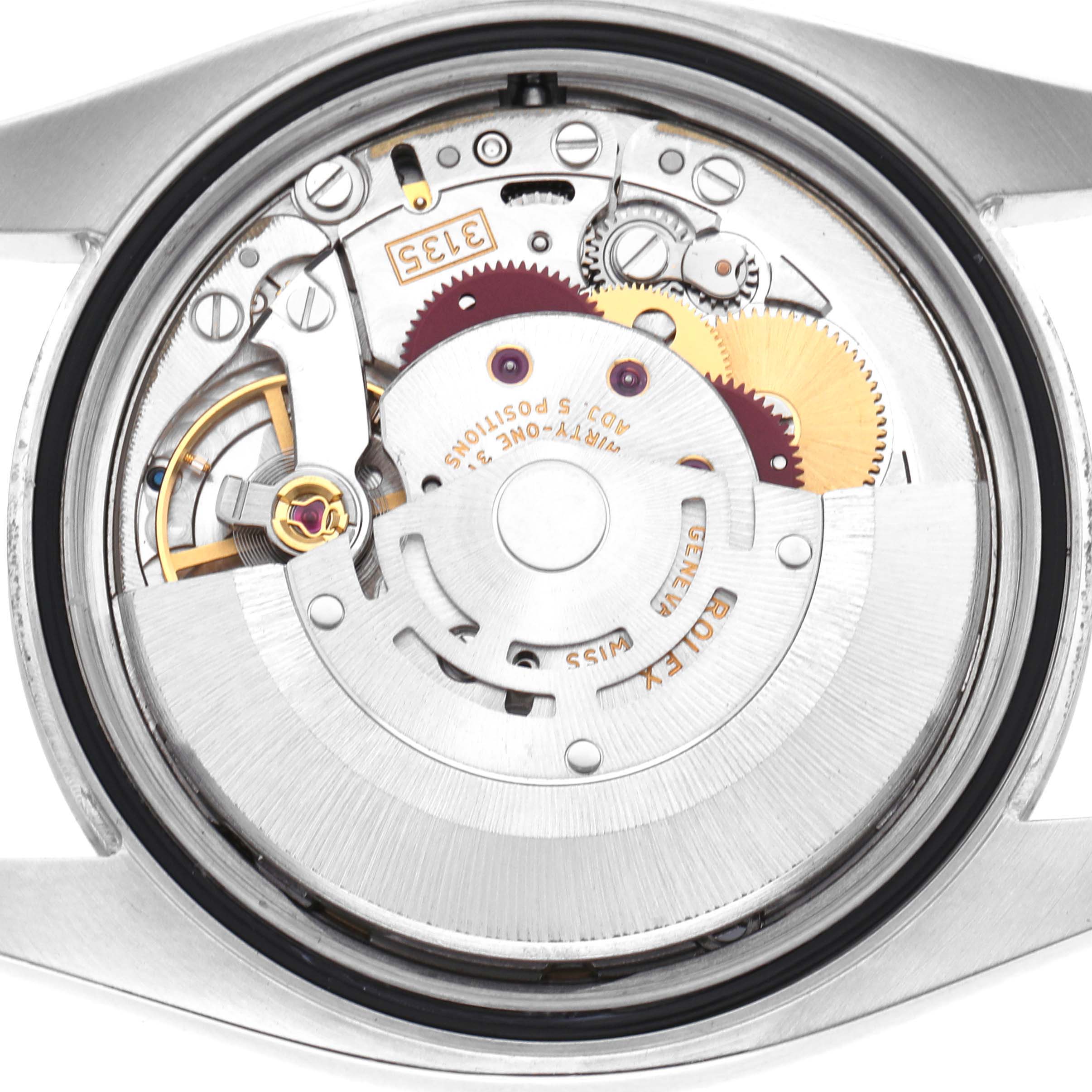 The image shows the intricate movement of a Rolex Datejust 116200 Men's Stainless Steel Blue Dial from a top-down angle, highlighting gears and the automatic rotor.