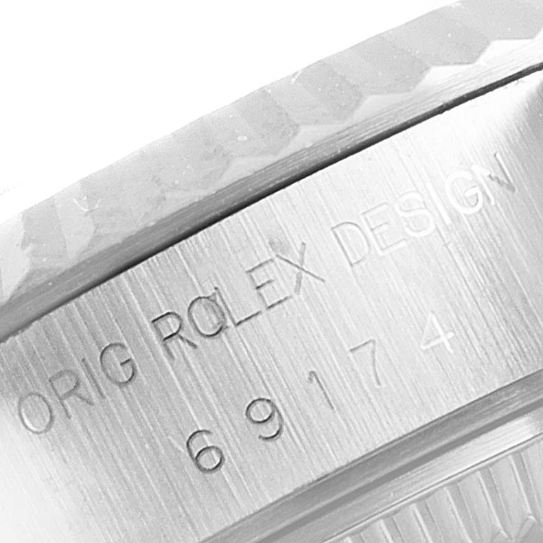 The image shows a close-up of the side of the bezel and case of a Rolex Datejust 69174 Women's Stainless Steel Silver Dial 69174 Women's Stainless Steel Silver Dial watch, highlighting the engraved text.