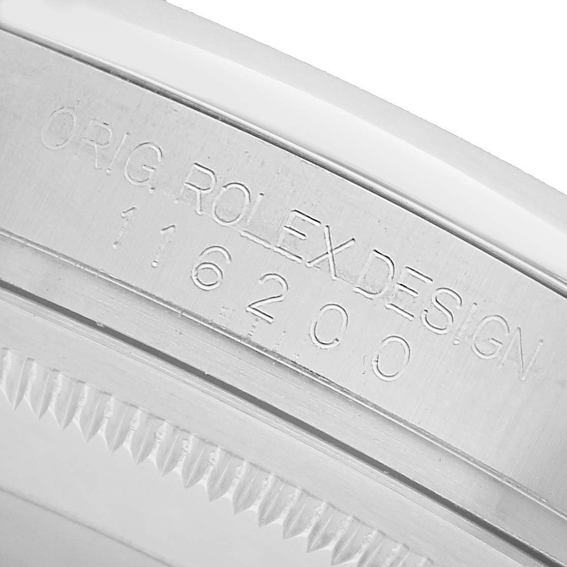 The image shows a close-up of the Rolex Datejust 116200 Men's Stainless Steel White Dial model's engraved case edge with reference number.