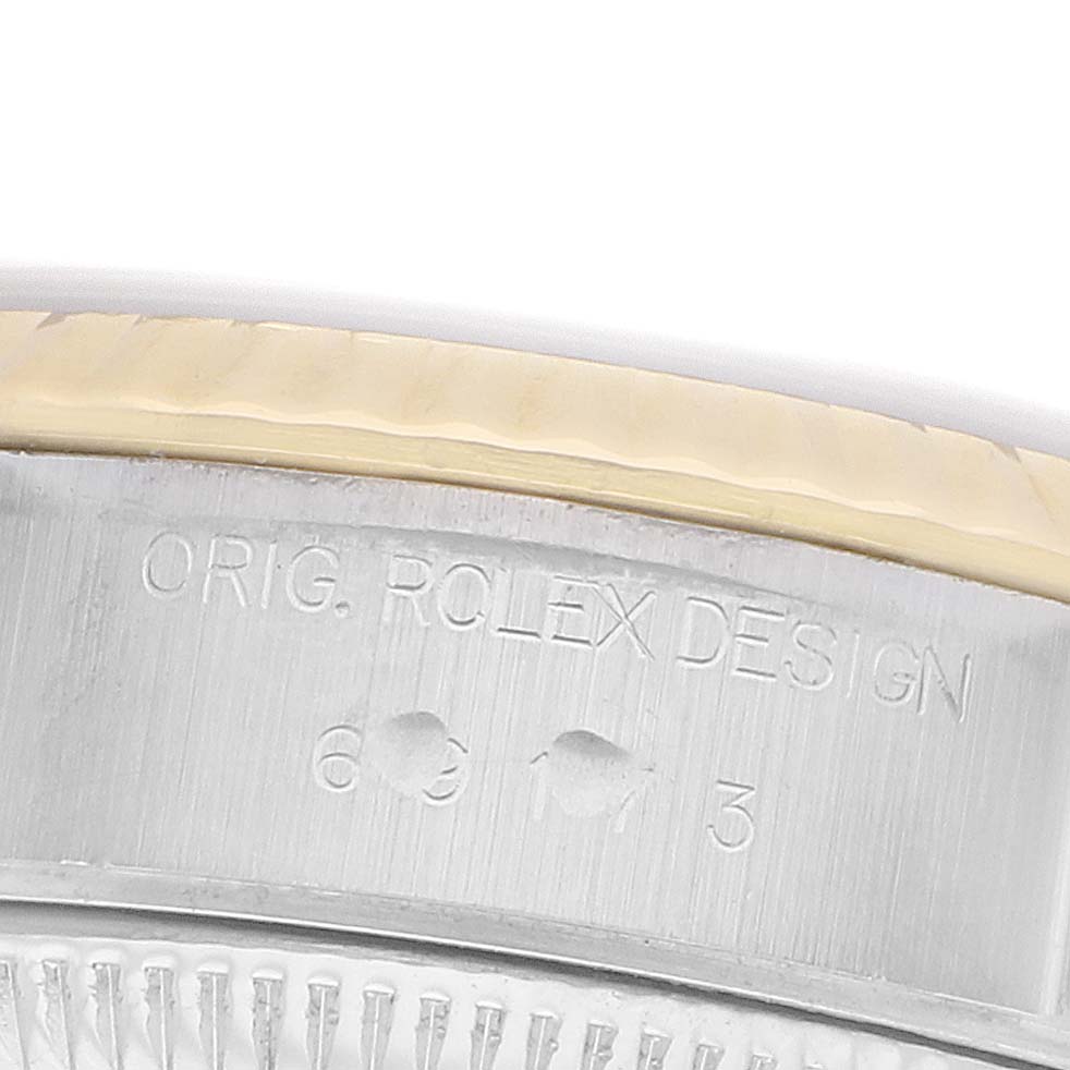 The image shows a close-up of the Rolex Datejust 69173 Women's Steel and Gold (two tone) Champagne Dial's side, focusing on the case edge with engraved text.