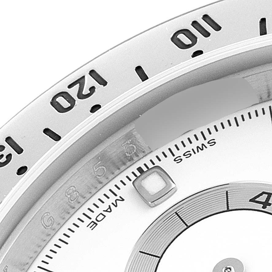 This image shows a close-up of the bezel and part of the dial of a Rolex Daytona 116520 Men's Stainless Steel White Dial 116520 Men's Stainless Steel White Dial watch.