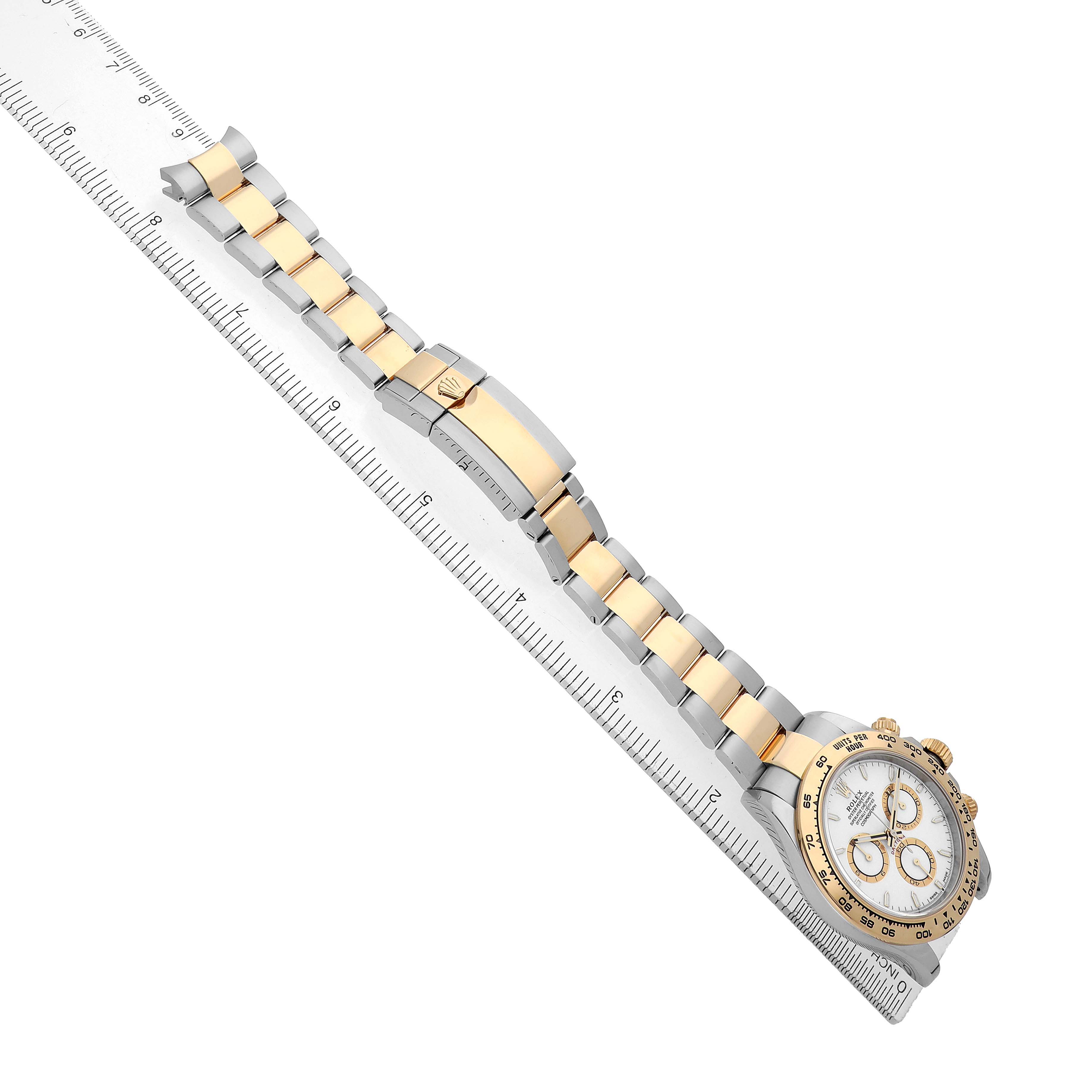 The Rolex Daytona 126503 Men's Steel and Gold (two tone) White Dial watch is shown from an angled top view, displaying the face, bezel, and band alongside a ruler.