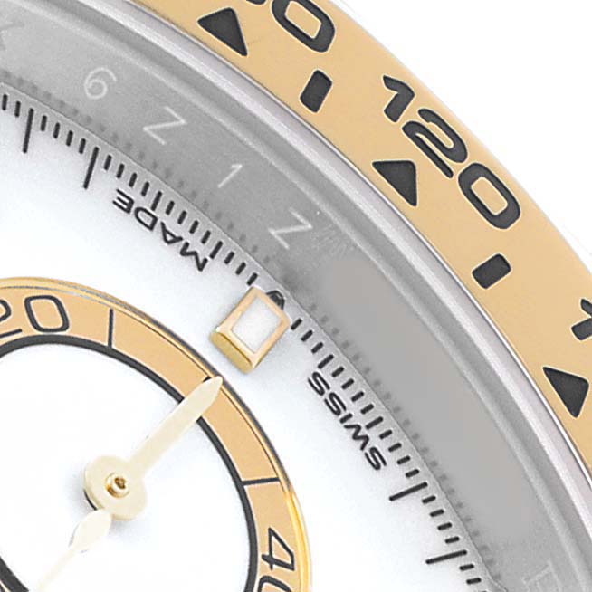 The image shows a close-up of the bezel and part of the dial of a Rolex Daytona 126503 Men's Steel and Gold (two tone) White Dial watch, highlighting the gold numerals and markings.
