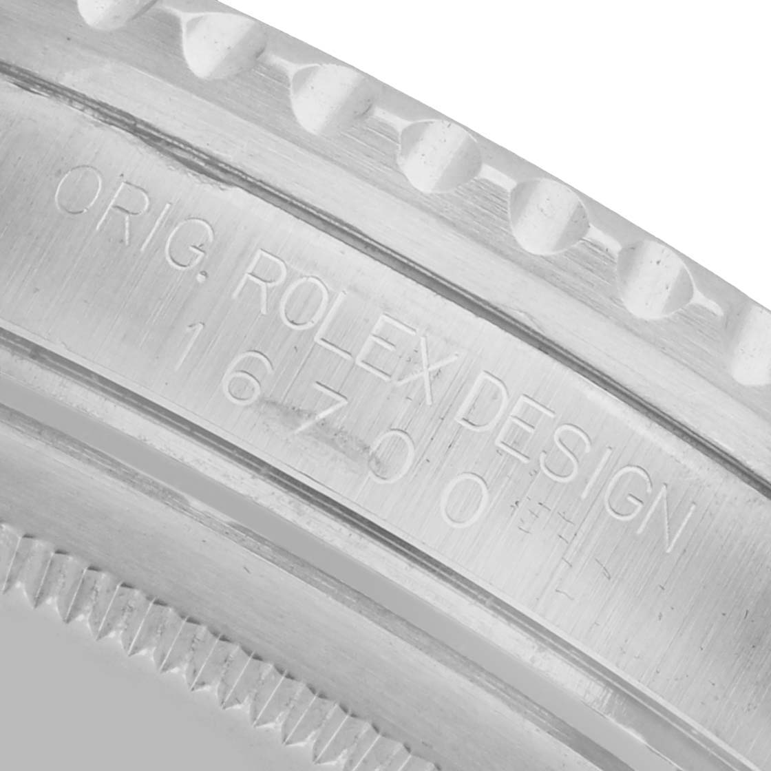 The image shows a close-up of the bezel engraving on a Rolex GMT-Master 16700 Men's Stainless Steel Black Dial, highlighting the model number and original design.