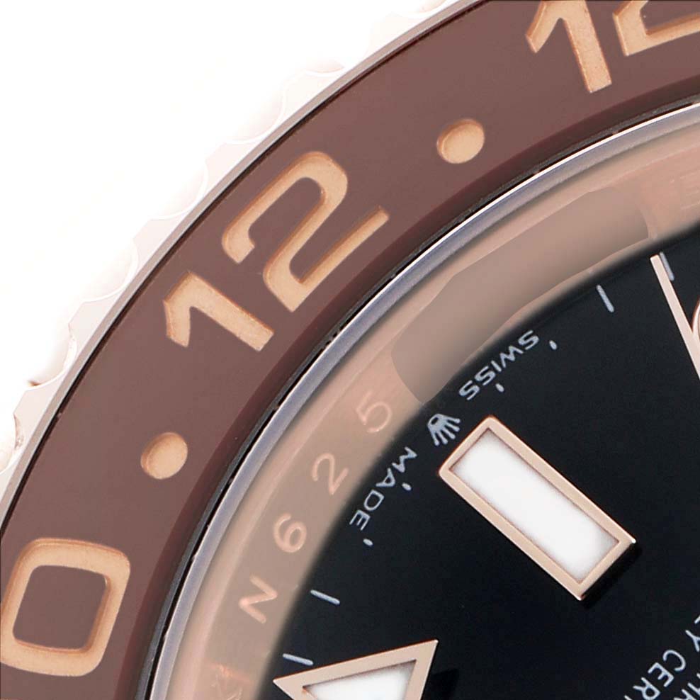 This close-up of the Rolex GMT-Master 126715 Men's Rose Gold Black Dial shows part of the bezel and dial from an angled top view.