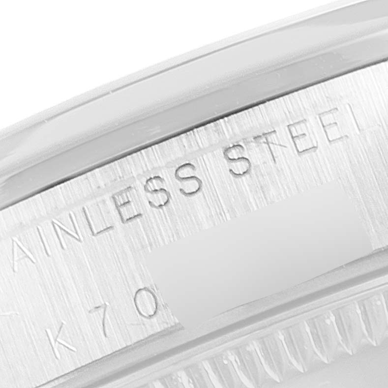 This close-up image shows the engraved stainless steel case of a Mid-Size Rolex watch.