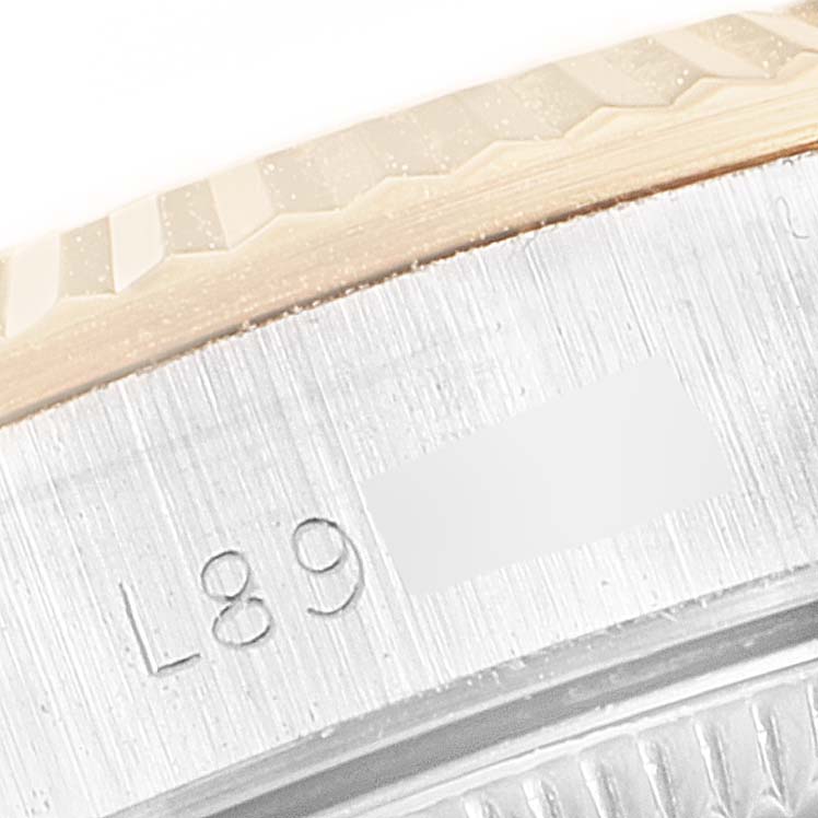 This close-up image shows the engraved serial number on the side of the case of a Rolex Oyster Perpetual 67193 Women's Steel and Gold (two tone) Champagne Dial 67193 Women's Steel and Gold (two tone) Champagne Dial watch.