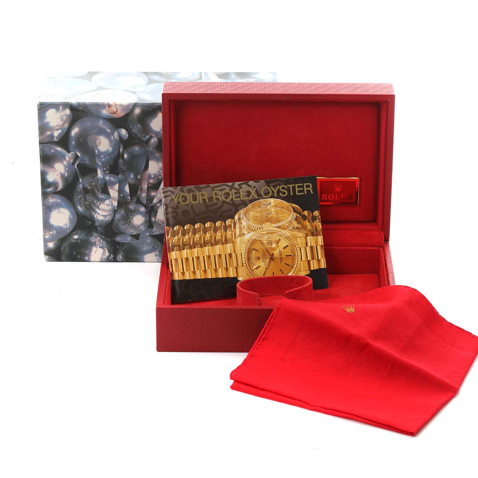 The image shows the packaging and accessories for a Rolex Datejust, featuring a box, booklet, and red cloth.