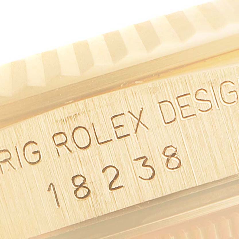 The image shows a close-up of the bezel and inscribed serial number (18238) on a Rolex President 18238 Men
s Yellow Gold Champagne Dial 18238 Men
s Yellow Gold Champagne Dial model watch.