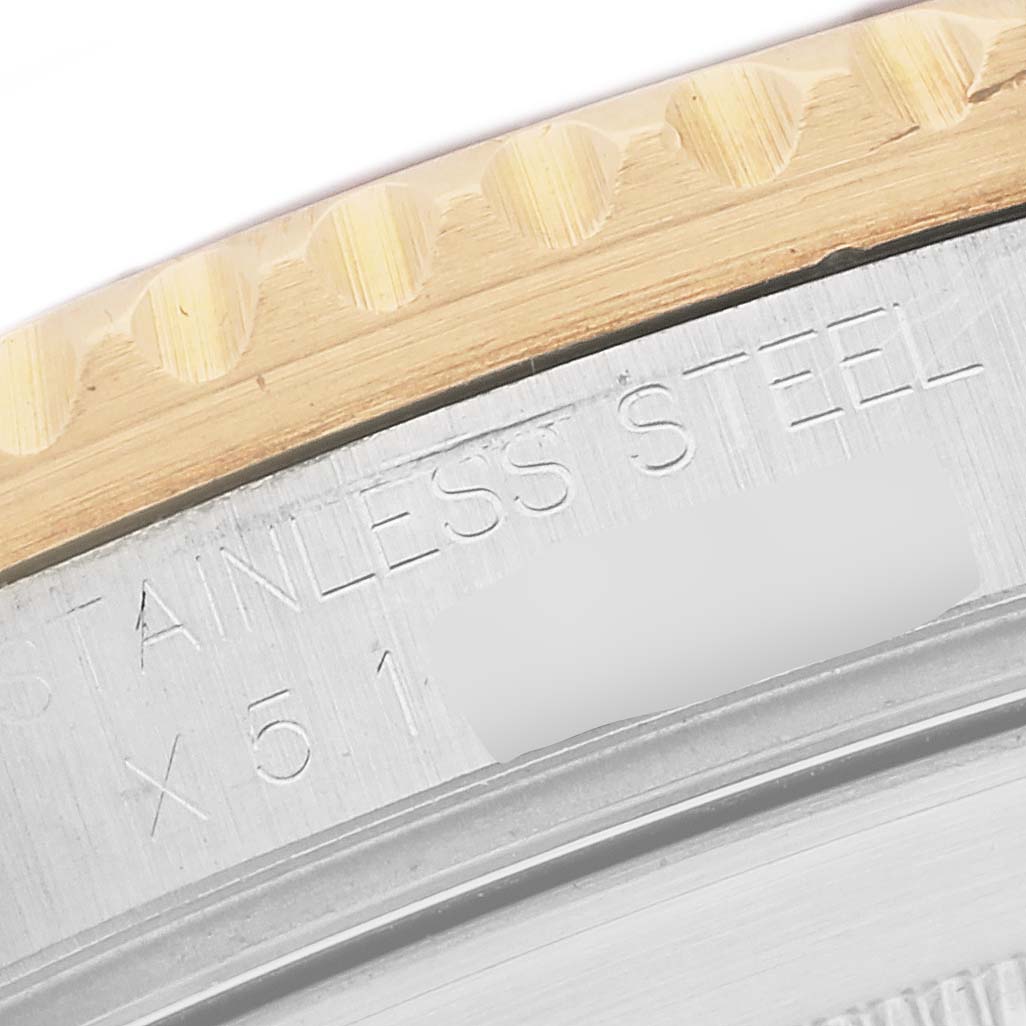 The image shows a close-up of the Rolex Submariner 16613 Men's Steel and Gold (two tone) Champagne Dial's engraved case with part of the bezel visible from the side.