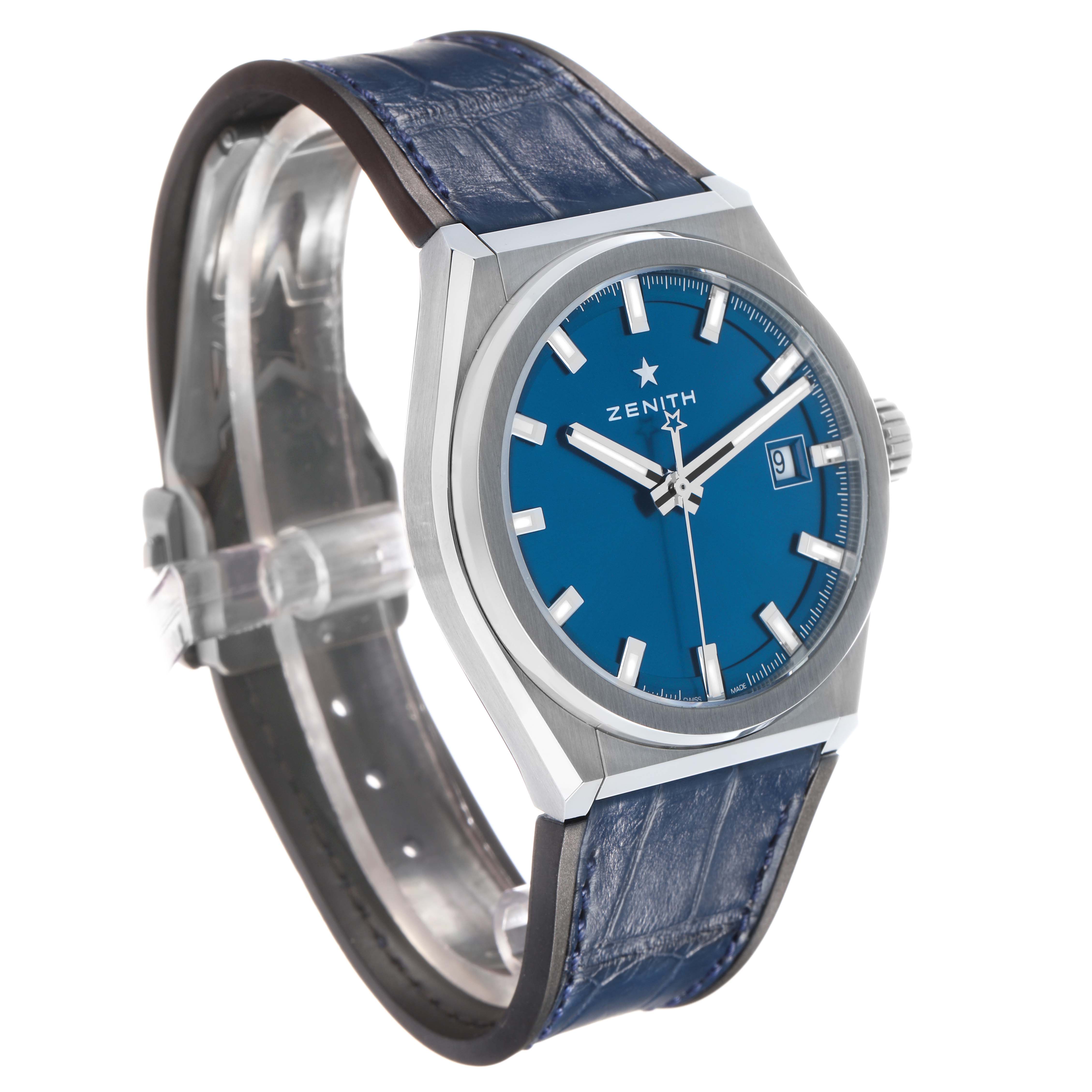 The Zenith Defy 95.9000.670/51 Men's Titanium Blue Dial watch is shown at a three-quarter angle, highlighting the blue dial, date window, and blue strap.
