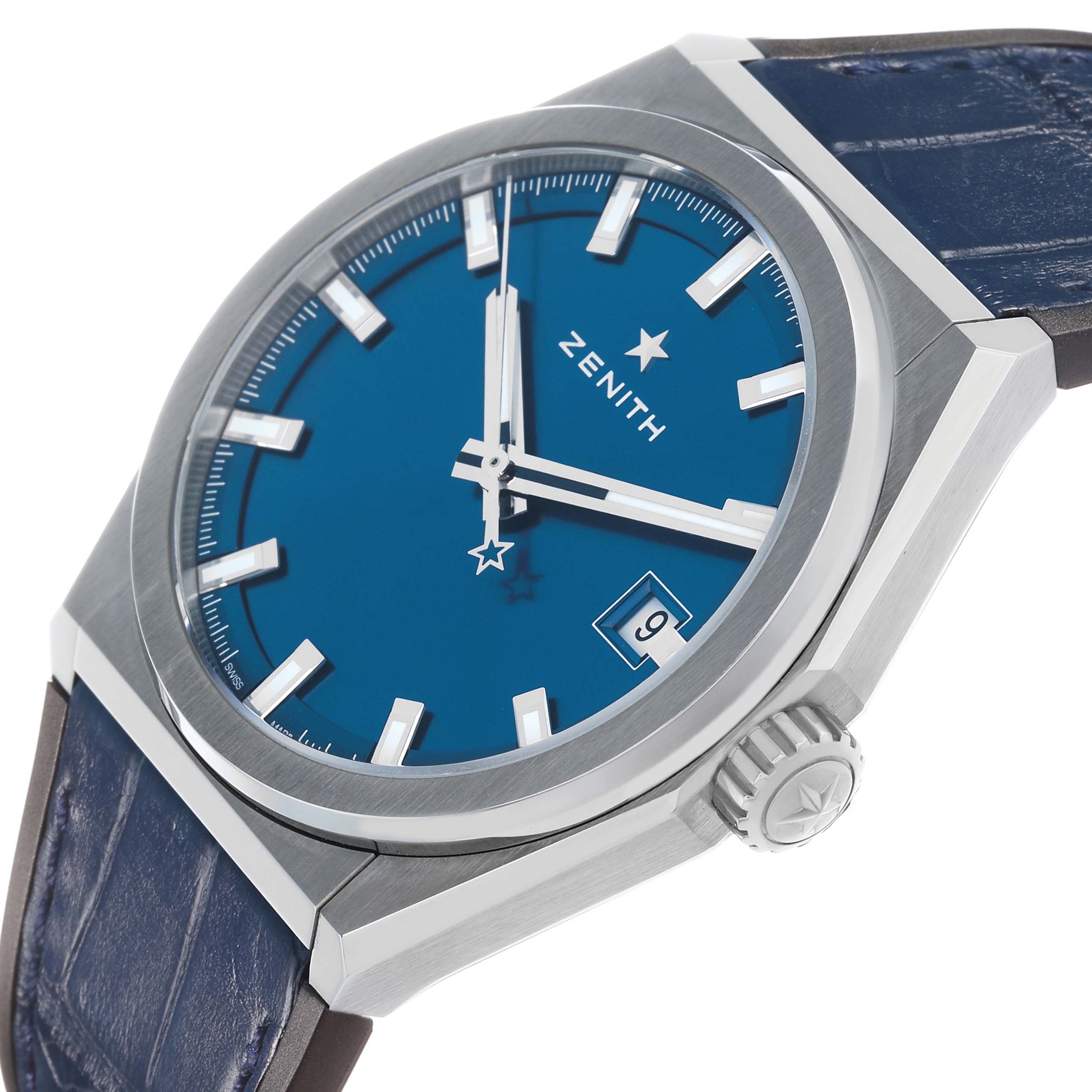 The Zenith Defy 95.9000.670/51 Men's Titanium Blue Dial watch is shown at a slight angle, highlighting the blue dial, hour markers, date window, and crown.