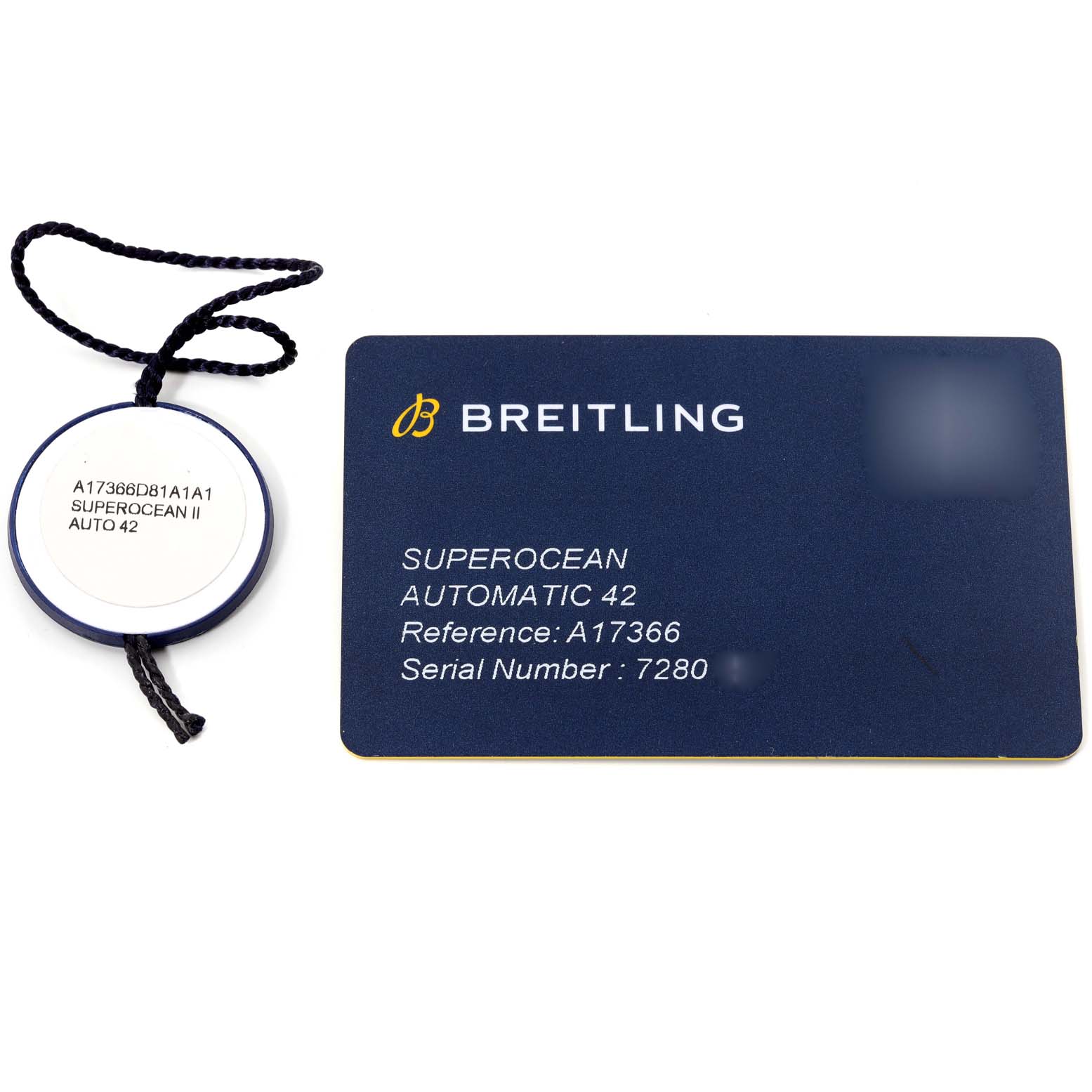 The image shows a Breitling Superocean A17366 Men's Stainless Steel White Dial A17366 Men's Stainless Steel White Dial Automatic 42 model reference tag and warranty card from a top-down angle.