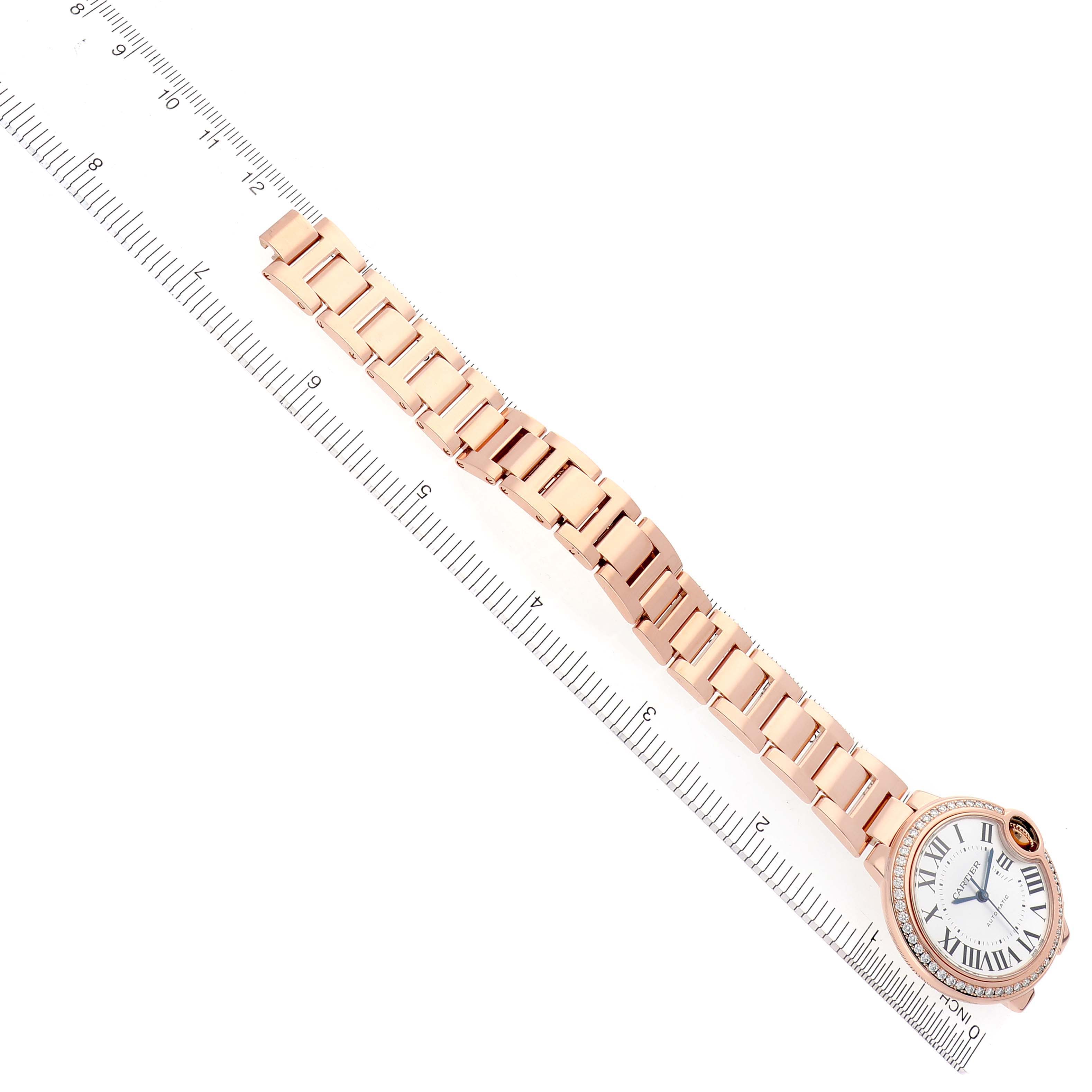 The Cartier Ballon Bleu WJBB0036 Women's Rose Gold Silver Dial WJBB0036 Women's Rose Gold Silver Dial watch is shown from a top view, displaying the face, bezel, and full bracelet against a measuring ruler.