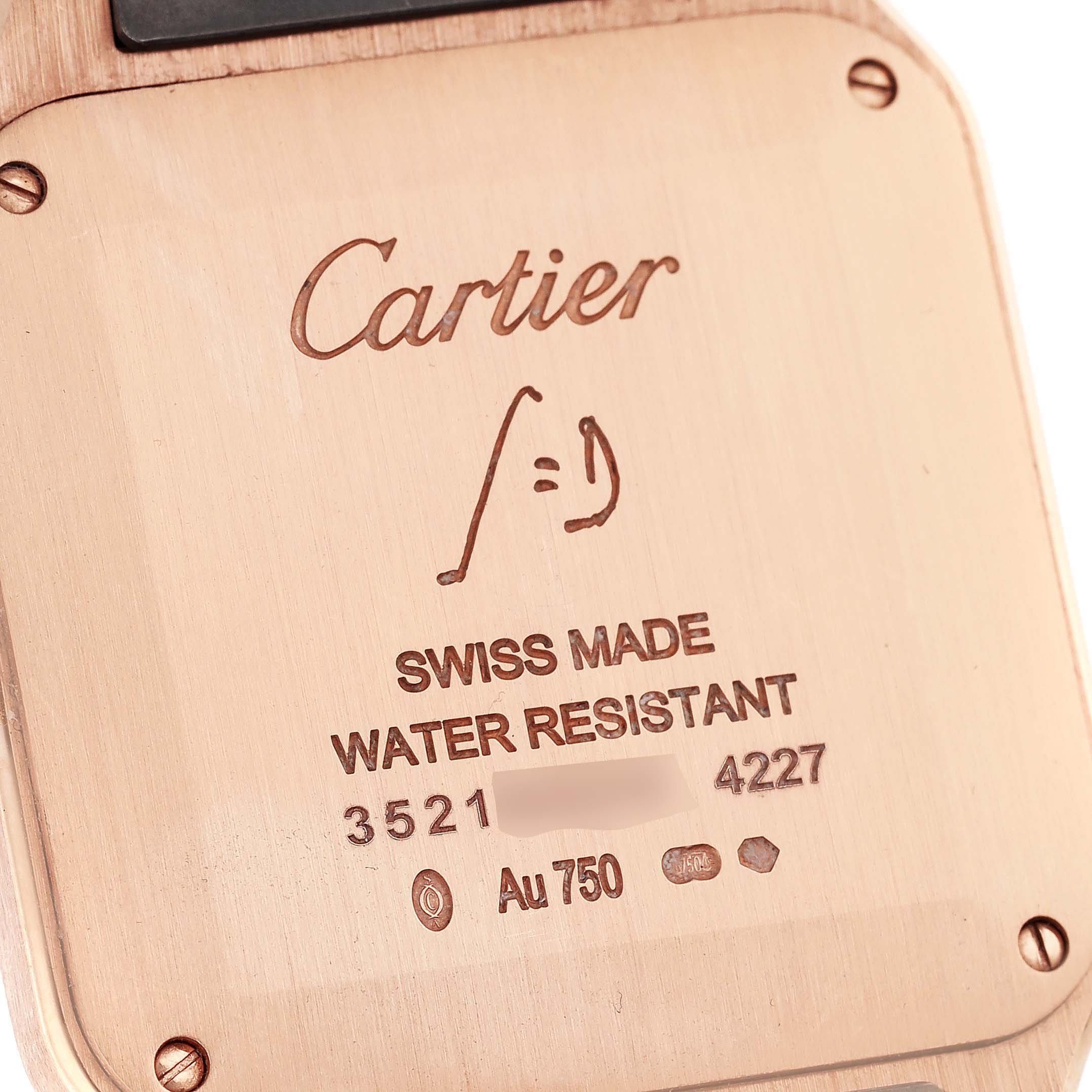 The image shows the back case of a Cartier Santos Dumont WGSA0021 Men's Rose Gold Silver Dial WGSA0021 Men's Rose Gold Silver Dial watch, highlighting the brand engraving and specifications.