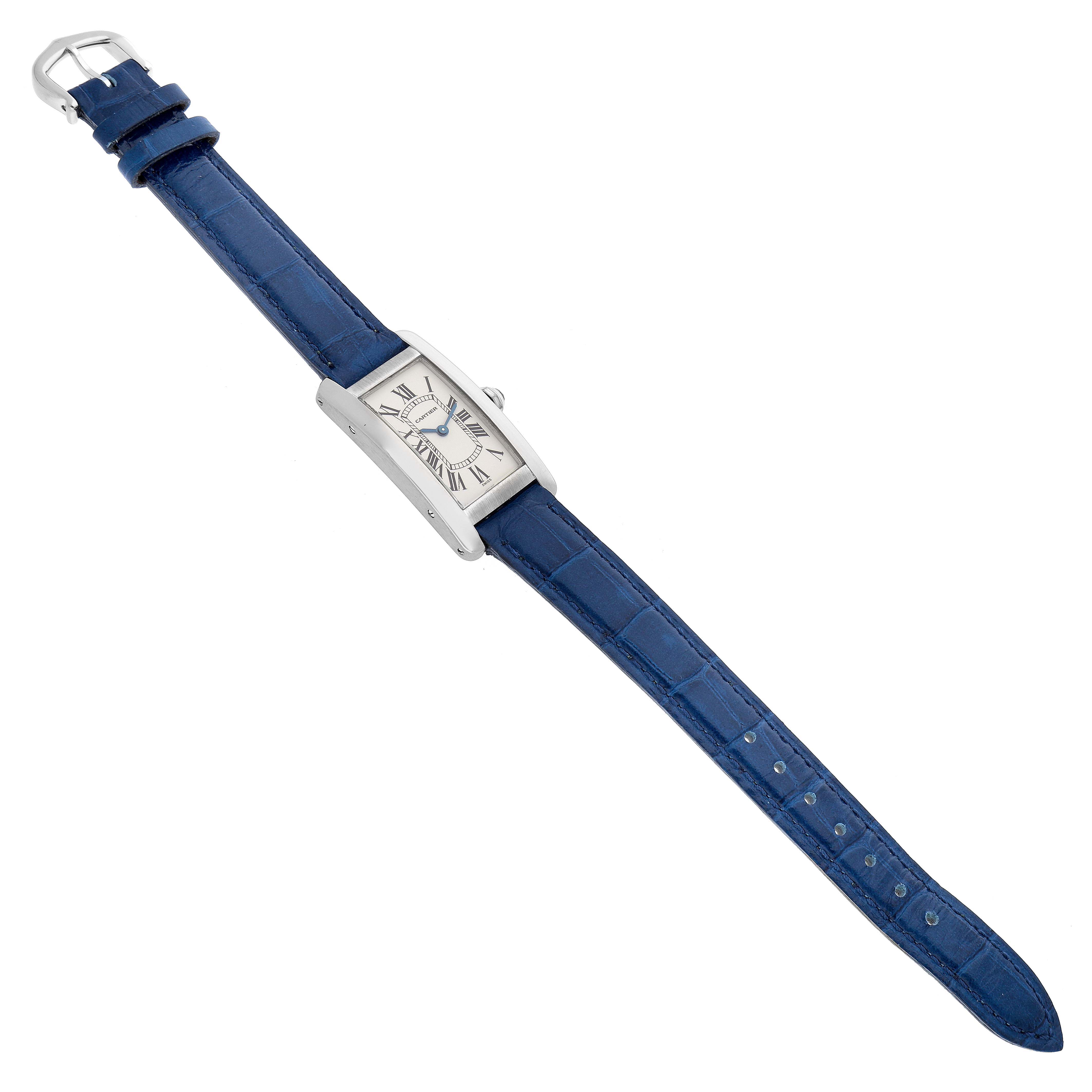 The Cartier Tank Americaine W2601956 Women's White Gold Silver Dial W2601956 Women's White Gold Silver Dial watch is shown at an angled top view, displaying its face, blue strap, and buckle.