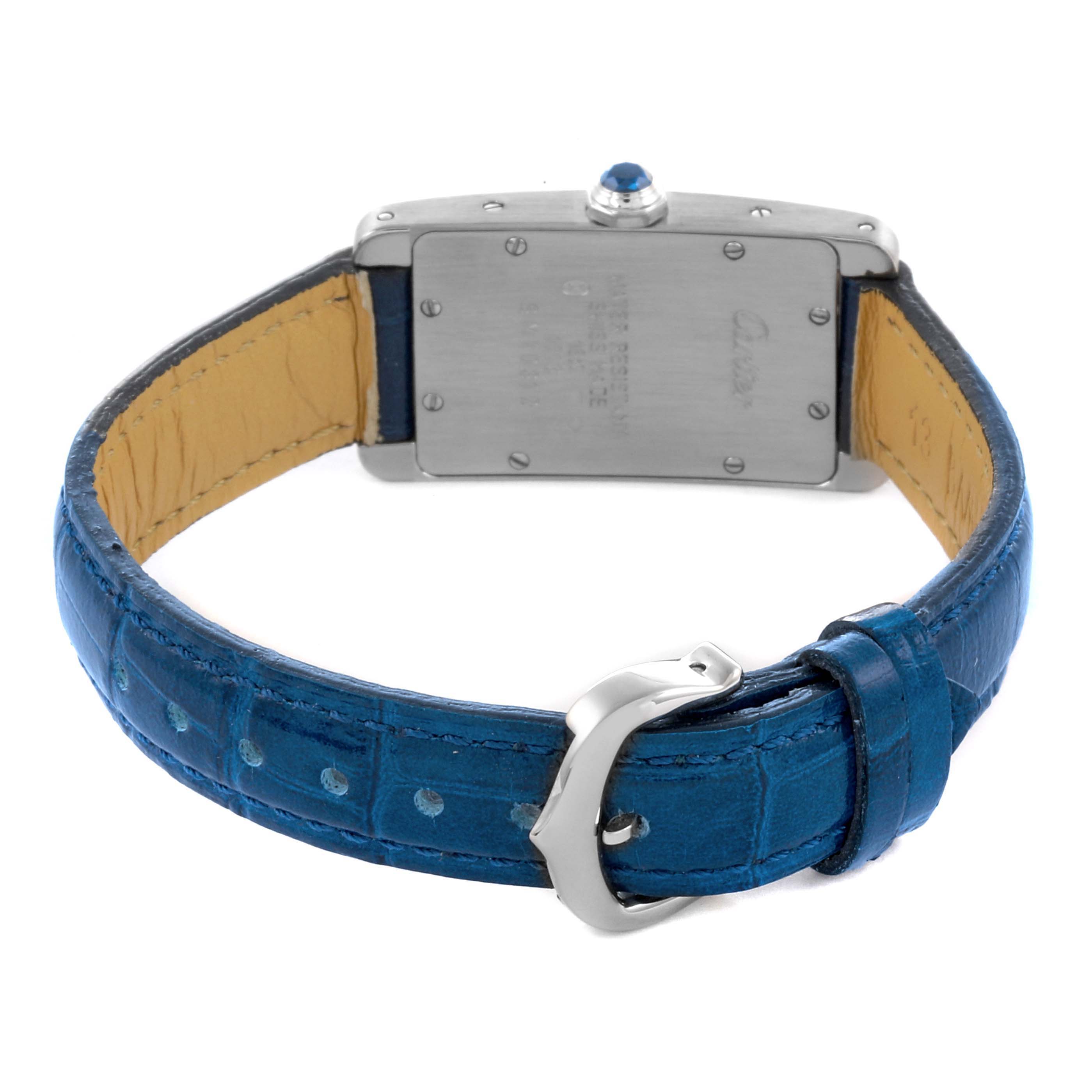 The image shows the back of the Cartier Tank Americaine W2601956 Women's White Gold Silver Dial W2601956 Women's White Gold Silver Dial watch, focusing on the case back and the blue leather strap with buckle.