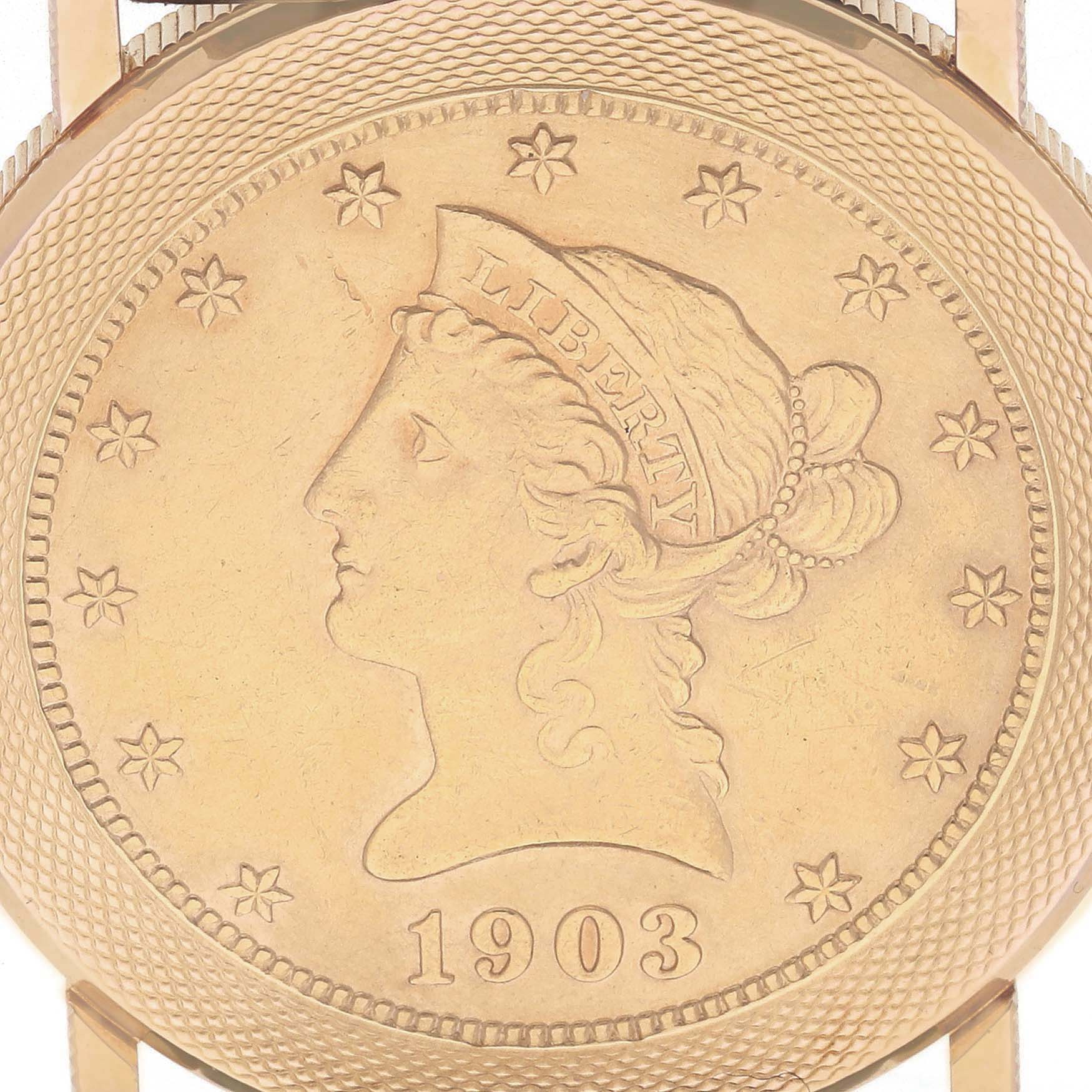 The image shows the Corum Coin Watch 1903 Men's Yellow Gold Yellow Dial 1903 Men's Yellow Gold Yellow Dial face, depicting a detailed design of a gold coin from 1903, viewed head-on.