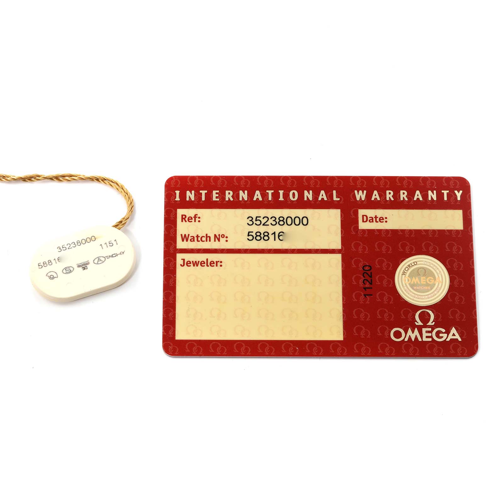 This image shows an Omega Speedmaster 3523.80.00 Men
s Stainless Steel Blue Dial 3523.80.00 Men
s Stainless Steel Blue Dial
s international warranty card and attached tag from a top-down perspective.