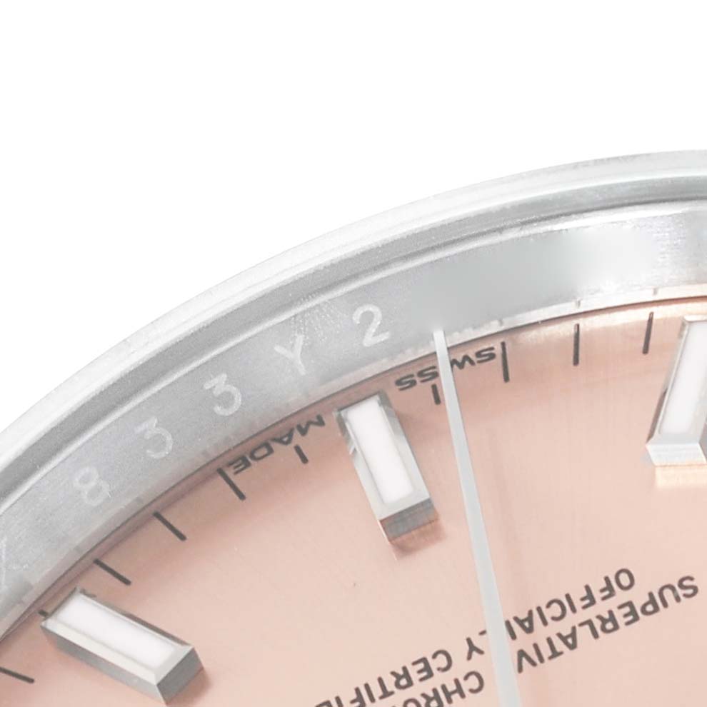 This close-up shows the dial, hour markers, minute hand, and part of the bezel of the Rolex Date 115200 Men's Stainless Steel Pink Dial 115200 Men's Stainless Steel Pink Dial model watch.