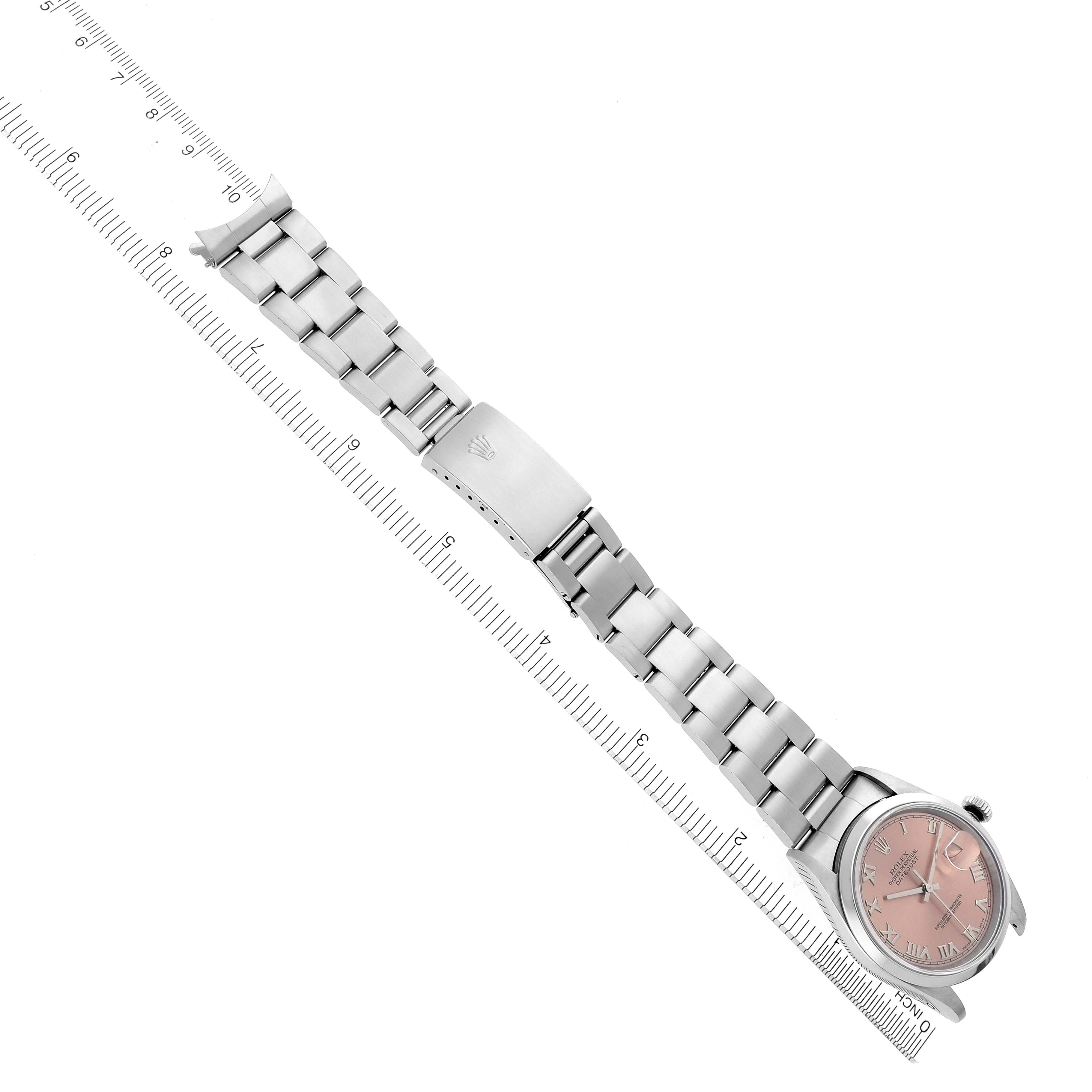 The Rolex Datejust 16200 Men's White Gold Pink Dial 16200 Men's White Gold Pink Dial watch is shown from a top angle, displaying the bracelet and clasp with a ruler for scale.