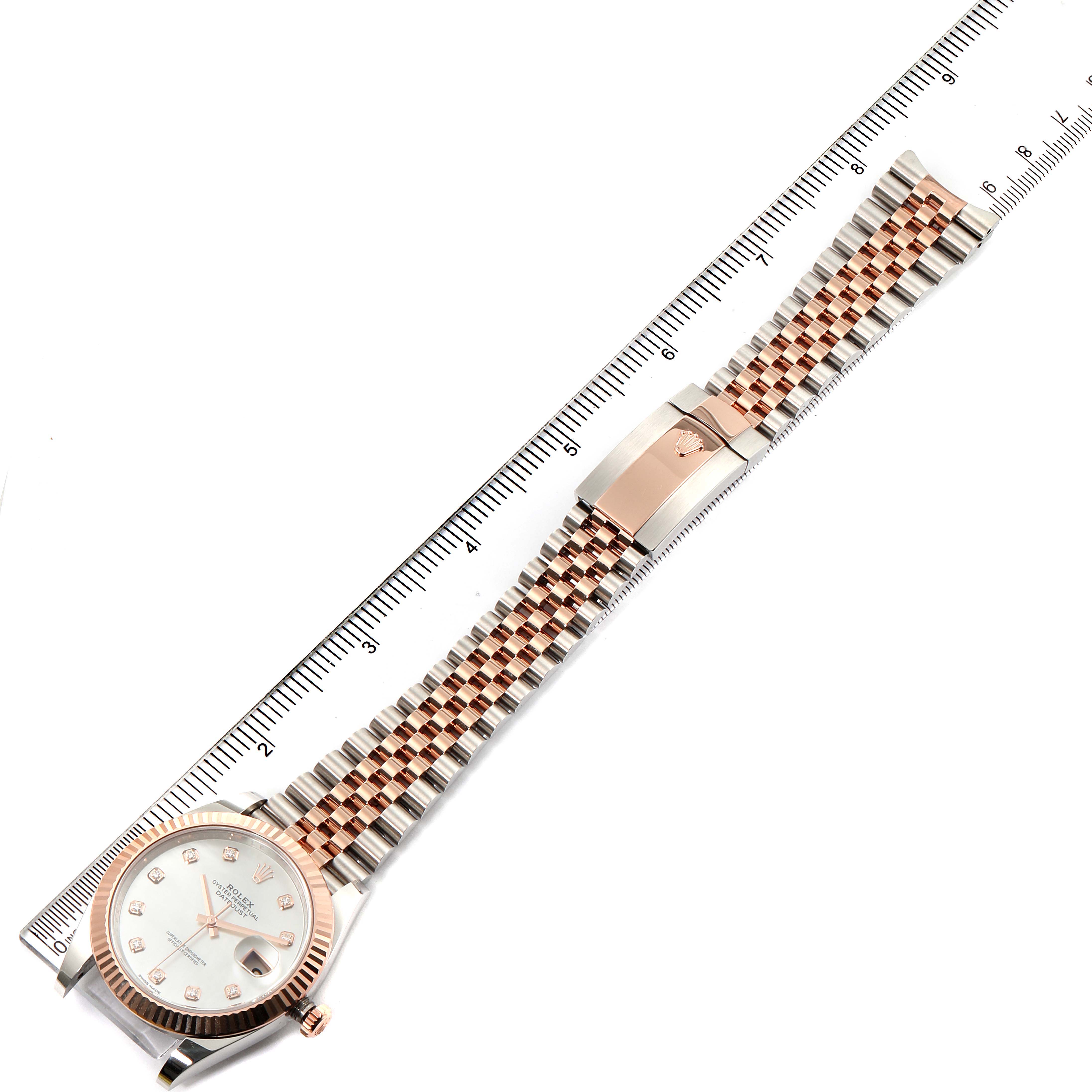 The Rolex Datejust 41 126331 Men's Steel and Gold (two tone) Mother of Pearl Dial 126331 Men's Steel and Gold (two tone) Mother of Pearl Dial watch is shown from a top-down angle, displaying the dial, bezel, and full bracelet against a ruler for scale.