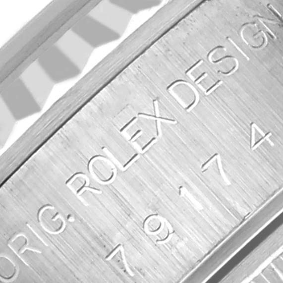 The image shows a close-up of the engraved side of a Rolex Datejust 79174 Women's Stainless Steel Blue Dial 79174 Women's Stainless Steel Blue Dial watch case, highlighting the brand and model details.