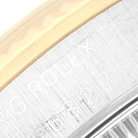 The image shows a close-up of the side engraving and the edge of the bezel from a Mid-Size Rolex watch.