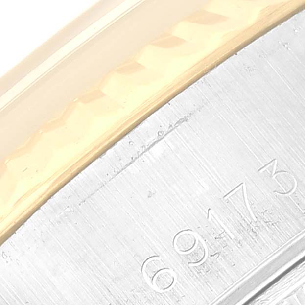 This close-up image shows the serial number engraving and part of the bezel of a Rolex Datejust 69173G Women's Steel and Gold (two tone) Silver Dial 69173G Women's Steel and Gold (two tone) Silver Dial watch.