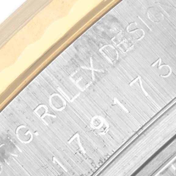 The image shows a close-up of the side engraving on the bezel and case of a Rolex Datejust 179173 Women's Steel and Gold (two tone) White Dial 179173 Women's Steel and Gold (two tone) White Dial watch.