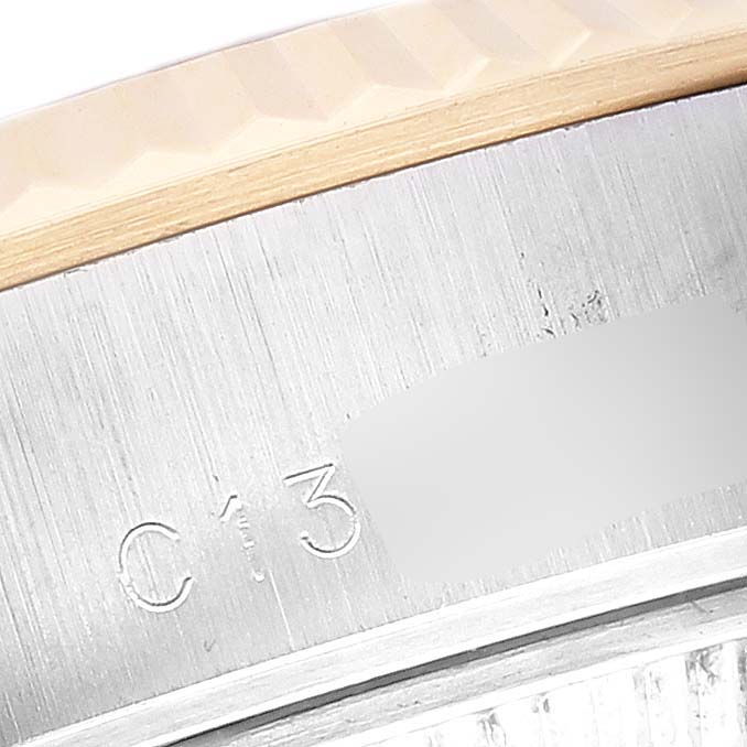 The image shows a close-up of the serial number engraving on the side of the bezel of a Rolex Datejust 69173 Women's Steel and Gold (two tone) White Dial 69173 Women's Steel and Gold (two tone) White Dial watch.