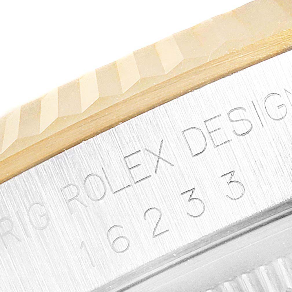 The image shows a close-up view of the serial number and fluted bezel of a Rolex Datejust 16233 Men's Steel and Gold (two tone) White Dial 16233 Men's Steel and Gold (two tone) White Dial watch.