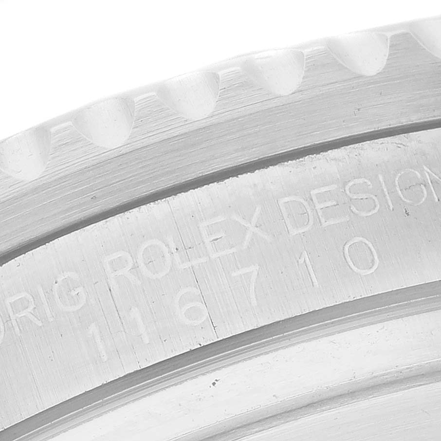 The image shows a close-up of the etched engravings and edge of the bezel of a Rolex GMT-Master 116710 Men
s Stainless Steel Black Dial 116710 Men
s Stainless Steel Black Dial watch.