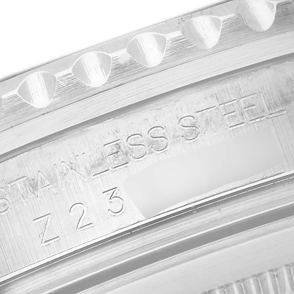 The image shows a close-up of the engraved side of a Rolex GMT-Master 16710 Men
s Stainless Steel Black Dial 16710 Men
s Stainless Steel Black Dial watch case with the bezel edge and serial number.