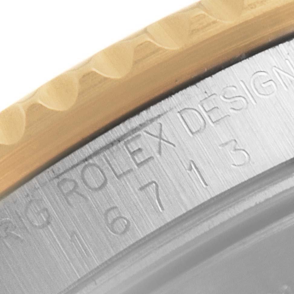 This close-up shows the bezel and engraved model number of the Rolex GMT-Master 16713 Men's Steel and Gold (two tone) Brown Dial 16713 Men's Steel and Gold (two tone) Brown Dial watch.
