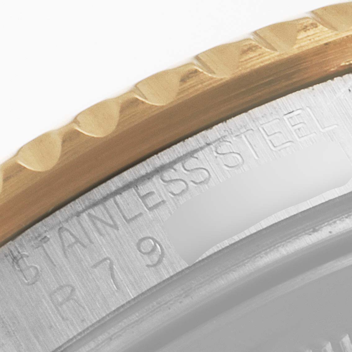 This close-up angle shows the bezel and case side of a Rolex GMT-Master 16713 Men's Steel and Gold (two tone) Brown Dial 16713 Men's Steel and Gold (two tone) Brown Dial, highlighting the "STAINLESS STEEL" engraving.