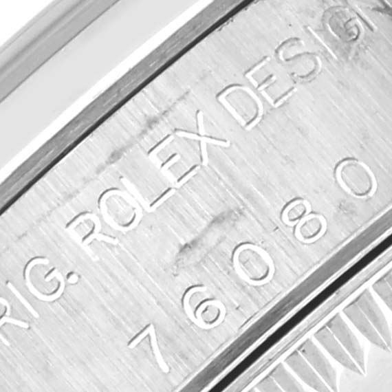 The image shows a close-up of the side of a Rolex Oyster Perpetual 76080 Women's Stainless Steel Silver Dial 76080 Women's Stainless Steel Silver Dial watch, highlighting engraved text and numbers.