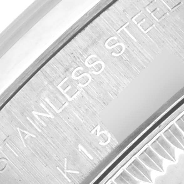 This image shows a close-up of the engraved stainless steel side of a Rolex Oyster Perpetual 76080 Women's Stainless Steel Silver Dial 76080 Women's Stainless Steel Silver Dial watch.