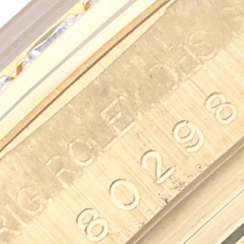 The image shows a close-up of the Rolex Pearlmaster 80298 Women's Yellow Gold Champagne Dial 80298 Women's Yellow Gold Champagne Dial's yellow gold inscription on the case edge, featuring serial numbers.