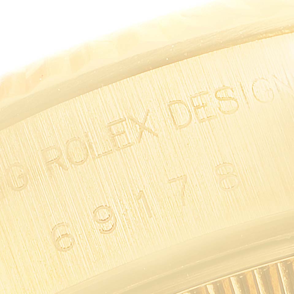 This image shows a close-up of the engraved serial number and "Rolex Design" on the side of a Rolex President 69178 Women
s Yellow Gold Champagne Dial 69178 Women
s Yellow Gold Champagne Dial model watch case.