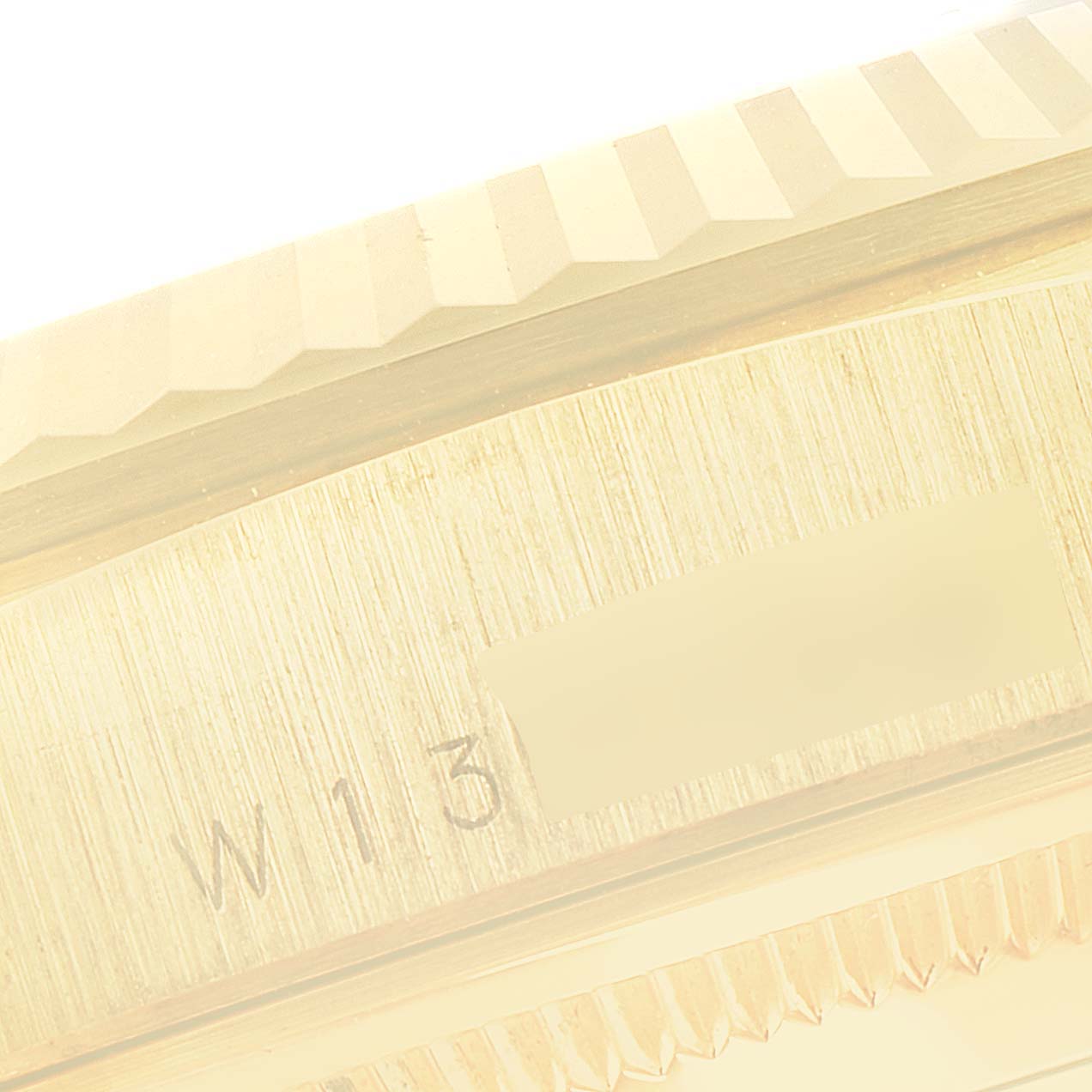 This image shows a close-up of the serial number engraving on the side of the bezel of a Rolex President 18238 Men's Yellow Gold Champagne Dial 18238 Men's Yellow Gold Champagne Dial watch.