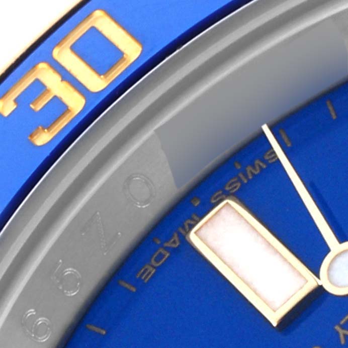 The image shows a close-up of the bezel and dial of a Rolex Submariner 116613LB Men's Steel and Gold (two tone) Blue Dial 116613LB Men's Steel and Gold (two tone) Blue Dial, highlighting the 30-minute mark and blue dial details.