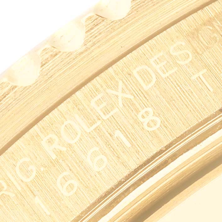 This is a close-up of the side engraving on the bezel of a Rolex Submariner 16618 Men's Yellow Gold Blue Dial 16618 Men's Yellow Gold Blue Dial watch.
