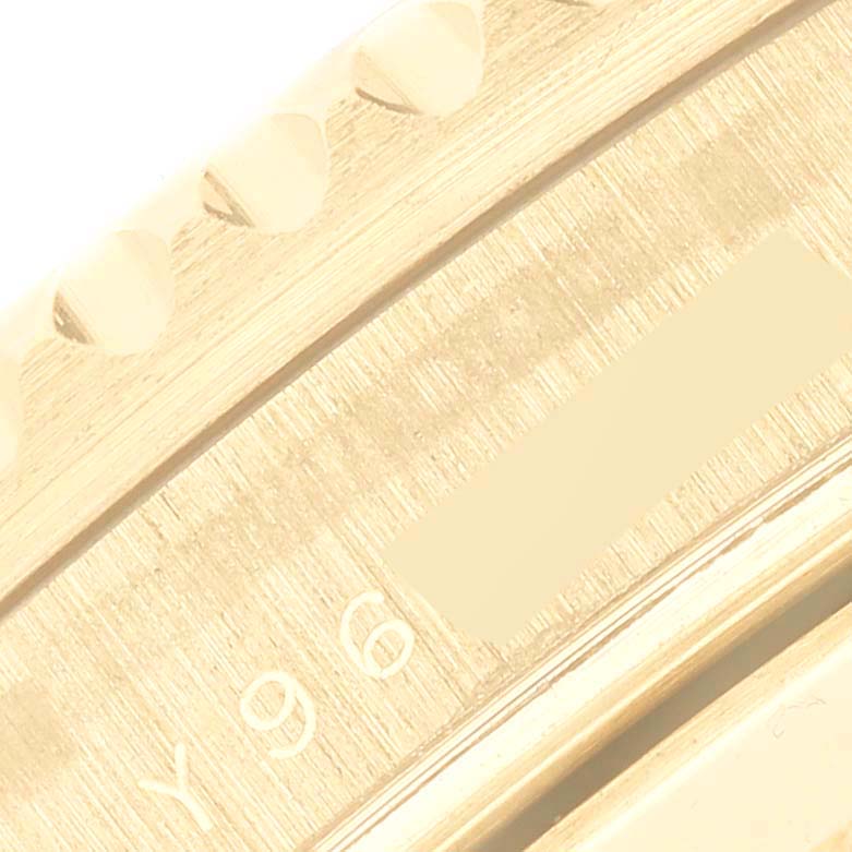 This close-up image shows the bezel and partial engraving on a Rolex Submariner 16618 Men's Yellow Gold Blue Dial 16618 Men's Yellow Gold Blue Dial watch.